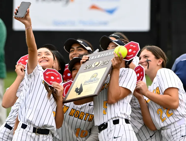 Huskies take a celebratory picture with their trophy after winning their CIF Southern Section Division 6 championship game against Village Christian in Irvine on May 19, 2023.