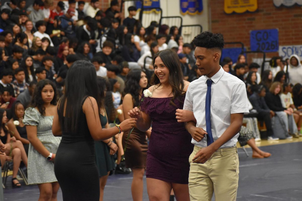 Madison, a nominee for Senior Queen, being escorted to her seat during the Homecoming Assembly. She is the representative for the Softball team.